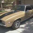 Fotograma coche descapotable dorado con rayas y capota negras Chevrolet Camaro Z/28 1969 de la serie La casa de empeños