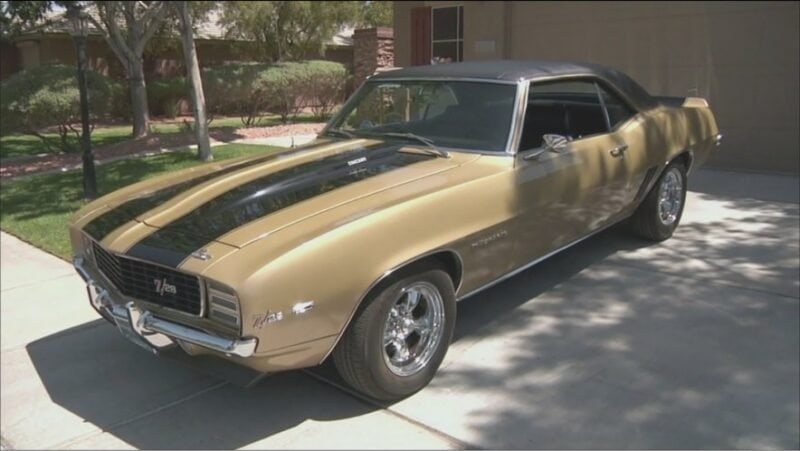 Fotograma coche descapotable dorado con rayas y capota negras Chevrolet Camaro Z/28 1969 de la serie La casa de empeños