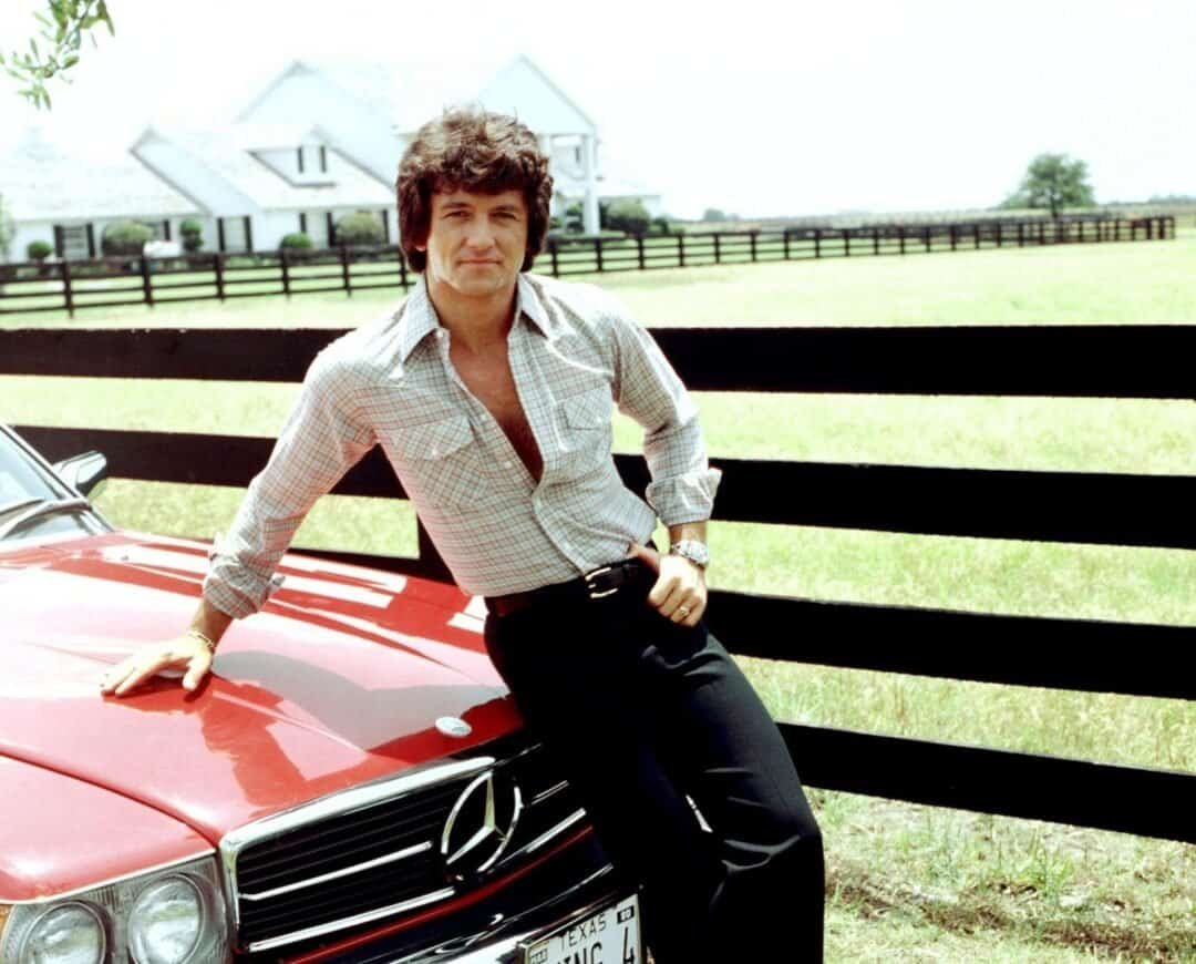 Bobby Ewing (Patrick Duffy) con Mercedes-Benz 450 SL 1979 color rojo de la serie Dallas